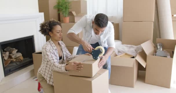 Молодая пара упаковывает коробки, чтобы вернуться домой — стоковое видео