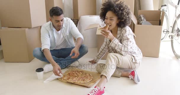 Joven pareja afroamericana metiéndose en una pizza — Vídeos de Stock
