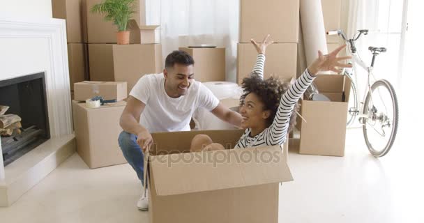 Happy mixed race couple having fun break with unpacking — Stock Video