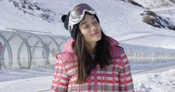 Jeune femme se relaxant sur la piste de ski en hiver — Photo