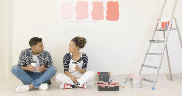 Jovem casal desfrutando de café enquanto renovando — Fotografia de Stock