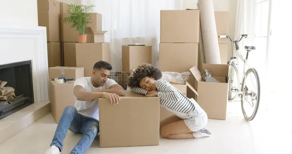 Cansado jovem casal relaxante em caixas de papelão — Fotografia de Stock