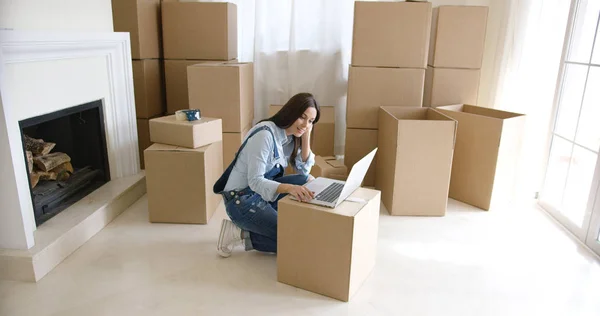 Fiatal nő használ egy laptop egy karton dobozban — Stock Fotó