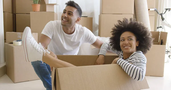 Jeune femme souriante dans un carton — Photo