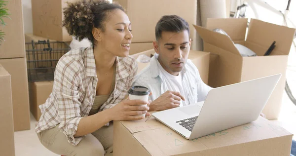 Jovem casal misto usando laptop — Fotografia de Stock