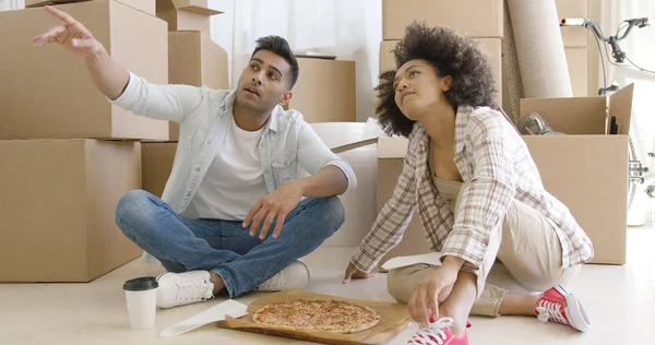Молода пара їсть піцу і спілкується — стокове фото