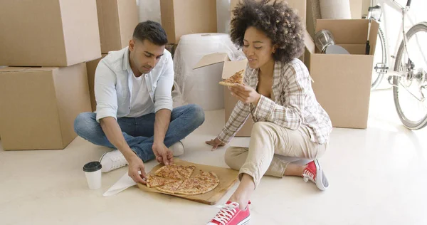 Joven pareja afroamericana metiéndose en una pizza —  Fotos de Stock