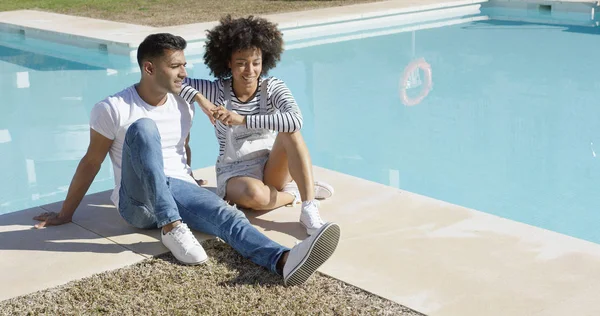 Mujer joven relajándose con su novio junto a la piscina — Foto de Stock