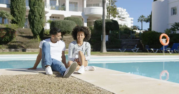 Junges Paar entspannt neben einem städtischen Pool — Stockfoto