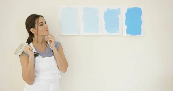 Jovem mulher escolhendo uma nova pintura para sua casa — Fotografia de Stock