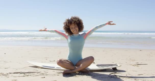 Женщина на доске для серфинга с поднятыми руками — стоковое видео