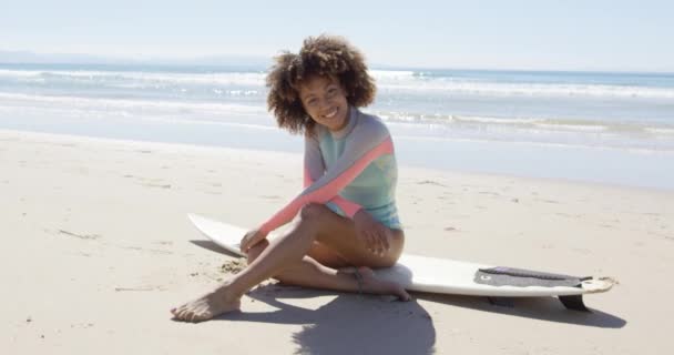 Mujer feliz sentada en una tabla de surf — Vídeos de Stock