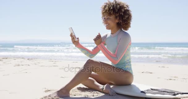 Sonriente hembra en la playa usando smartphone — Vídeo de stock
