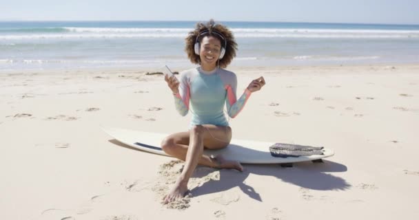 Жінка слухає музику на пляжі — стокове відео