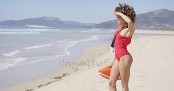 Weibchen blickt am Strand in die Ferne — Stockvideo