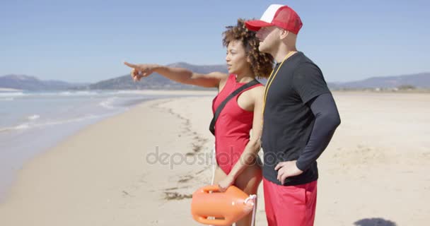 Vrouwelijke wijzen met de vinger staande op strand — Stockvideo