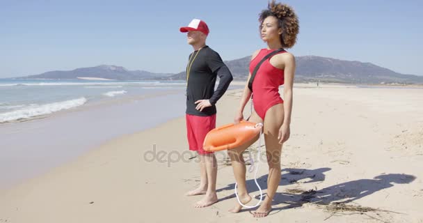 Спасатели-женщины и мужчины позируют на пляже — стоковое видео