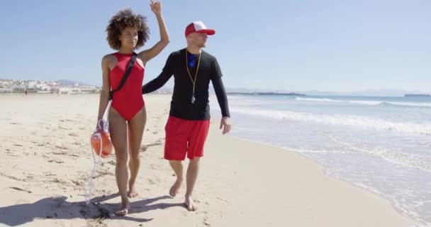 Vrouwelijke wijzen in de verte op strand — Stockvideo