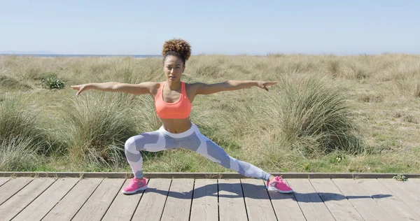 Deportiva mujer estirándose sobre pavimento —  Fotos de Stock