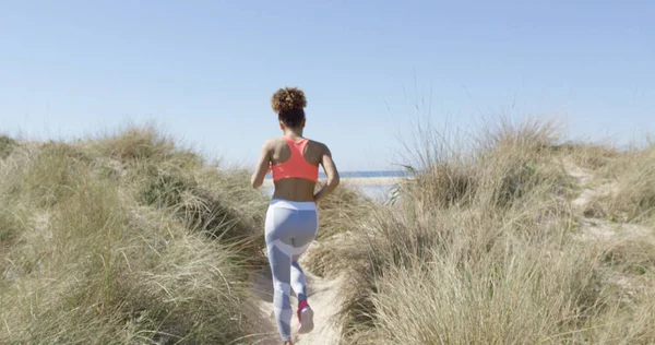 Frau joggt am Strand — Stockfoto