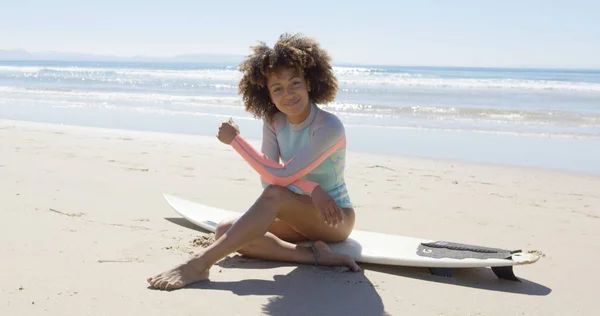 Gelukkige vrouw zitten op een surfplank — Stockfoto