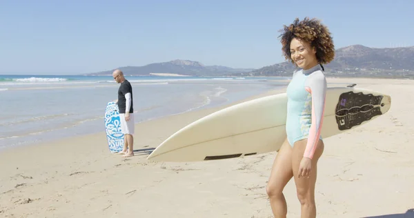 Feminino segurando prancha de surf no belo fundo da praia — Fotografia de Stock