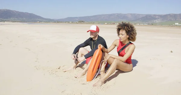 女性と男性のライフ セーバーがビーチをパトロール — ストック写真
