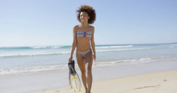 Женщина держит ласты на пляже — стоковое фото