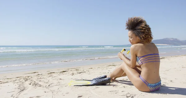 Kvinna med simfötter som sitter på stranden — Stockfoto
