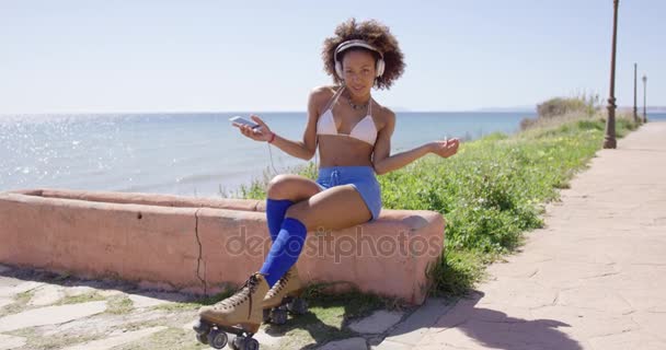 女性の身に着けているローラー スケート聞く音楽 — ストック動画