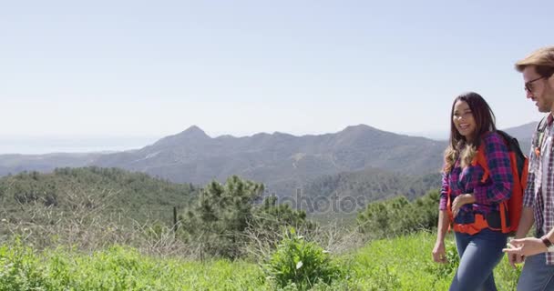 Pareja joven caminando en las montañas — Vídeos de Stock