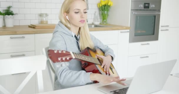 Girl practicing guitar and using laptop — Stock Video