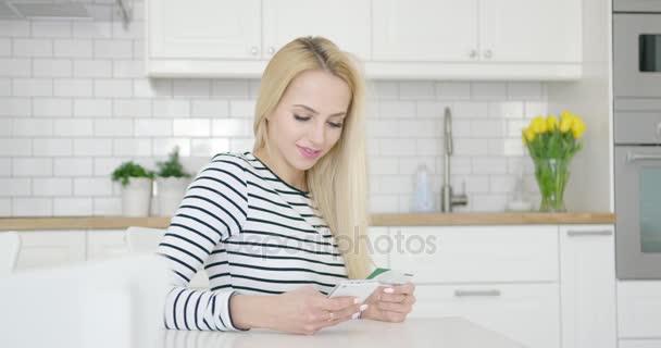 Χαμογελαστό θηλυκό χρησιμοποιώντας πιστωτική κάρτα και τηλέφωνο — Αρχείο Βίντεο