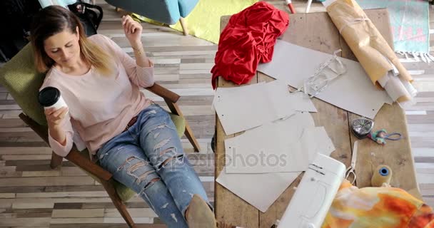 Female tailor having rest in workshop — Stock Video