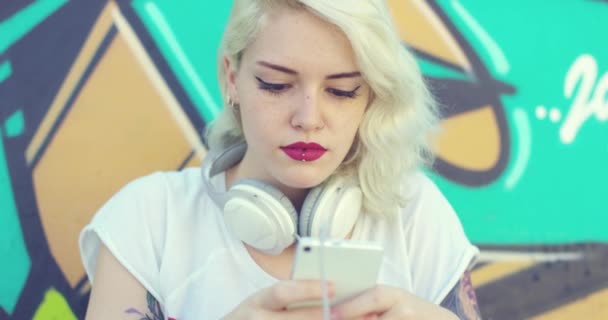 Hipster mujer navegando por su móvil para la música — Vídeos de Stock