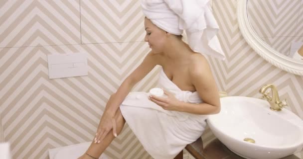 Женщина применяет лосьон в ванной комнате — стоковое видео