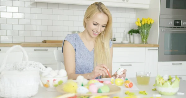 Cheerful woman painting Easter eggs — Stock Photo, Image