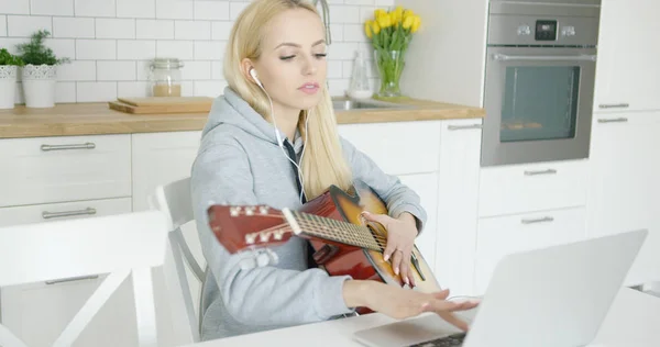 Κορίτσι εξάσκηση κιθάρας και να χρησιμοποιούν φορητό υπολογιστή — Φωτογραφία Αρχείου