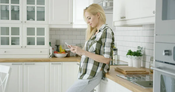 Jovem mulher usando telefone em casa — Fotografia de Stock