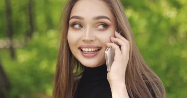 Смеющаяся девушка разговаривает по телефону — стоковое видео