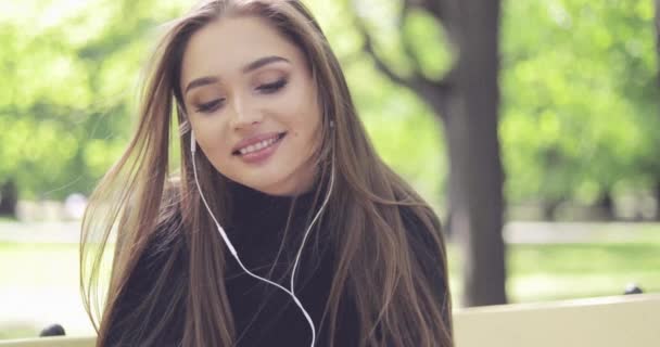 Mujer sonriente en auriculares posando — Vídeos de Stock
