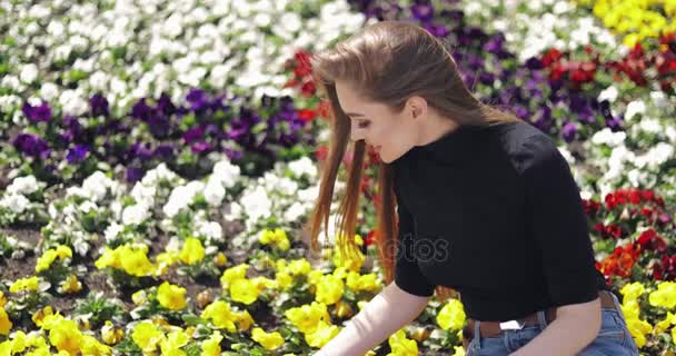 Femme posant avec des fleurs sur le sol — Video