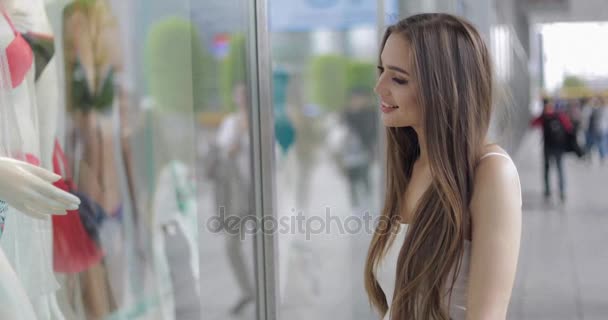 Smiling girl looking at shop window — Stock Video