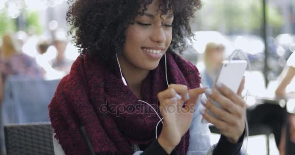 African woman with smartphone in cafe — Stock Video