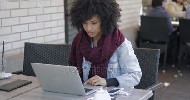 Mooi meisje met laptop in buiten café — Stockvideo
