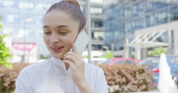 Любимая девушка разговаривает по телефону на городском фоне — стоковое видео