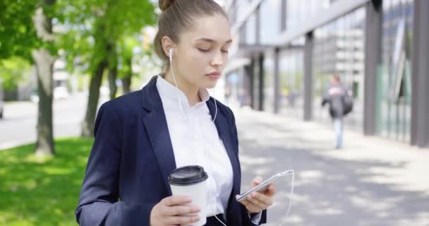 Chica en traje con café y teléfono inteligente — Vídeo de stock