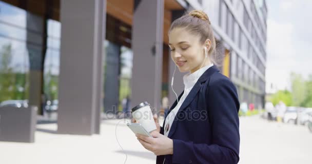 Dziewczyna zawartości przy użyciu telefonu i picia kawy — Wideo stockowe