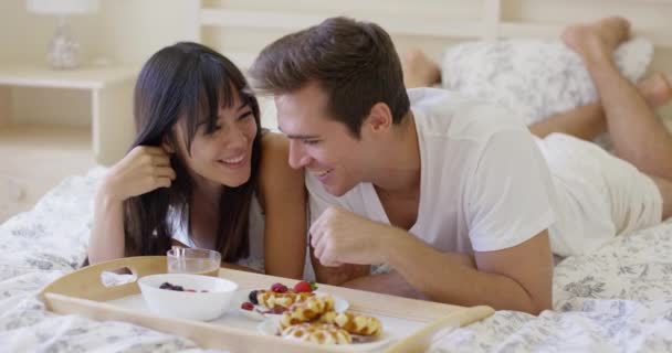 Chichotání pár má snídaně v posteli — Stock video