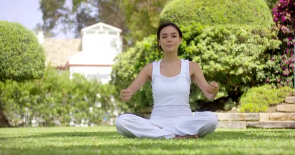 Чудова молода жінка в білому сидить на газоні — стокове відео